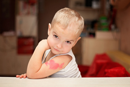 Cute little boy showing his heart symbol tattoo, he falls in love, romantic and love concept, Valentine Day greetingの写真素材