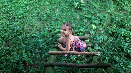 Happy cute kid playing in the treehouse in summer, happy summertime in countryside, ecological playgroundの写真素材