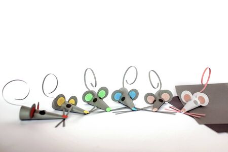 Cute little 7-8 years old girl making crafted  mice with colored paper and decorative punchers, color paper to create fun and easy with children, concept for kindergarten, 2020 year animal symbolの写真素材