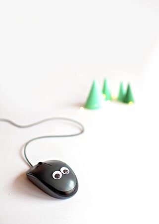 Gray computer mouse with cable and toy eyes over white background, business and holidays, festive card for IT-worker, computer device like 2020 year symbolの写真素材