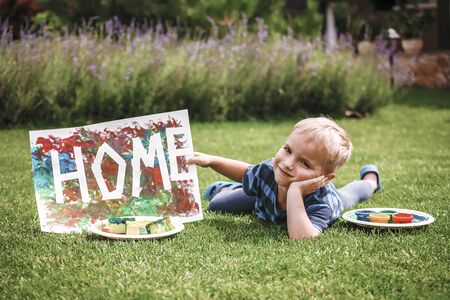 Cute toddler with darling hand print project kept his busy at home or outside at summer, drawing...