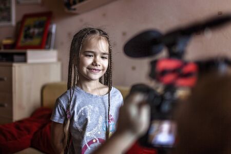 Happy cute sibling speaking in front of camera at home, future reporters, online learning concept, filming for internet, smart activity holidays and quarantine indoorの写真素材
