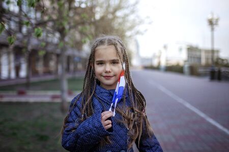 Happy little girl wearing off the respirator medical mask in national France colors because of the end of quarantine in the country, happiness and hope, stop virus spreading, outdoor lifestyleの写真素材