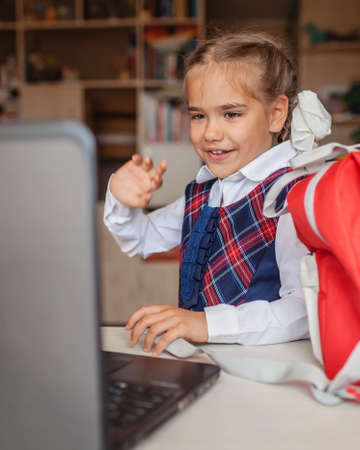 Back to school. Cute scholar girl sharpening colorful pencils and reading electronic book with tablet at the same time, ready back to school, multi-tasking and education conceptの写真素材