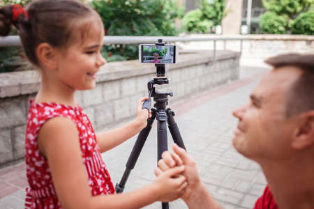 Make money online. Middle aged father and his daughter reviewing recorded film for family channel, video blogger, internet earning and freelance remote workの写真素材