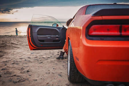 Autumn road trip, freedom and solo traveler. Pretty woman sitting in the car on the bank of sea,...