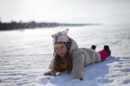 Happy cute preschool girl having fun, playing at winter walk outdoors, winter family lifestyleの写真素材