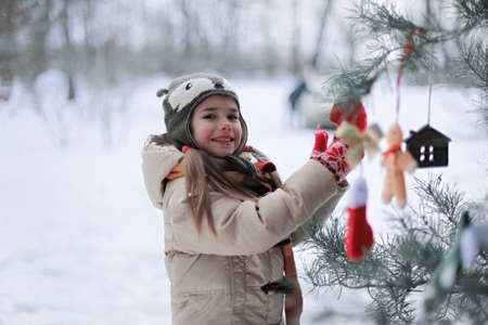 Happy cute preschool girl having fun, playing at winter walk outdoors, winter family lifestyleの写真素材