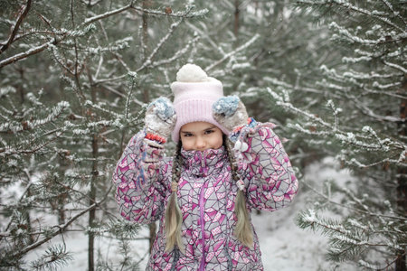 Kids enjoy first snow in winter forest and have fun together, active winter weekend, seasonal...