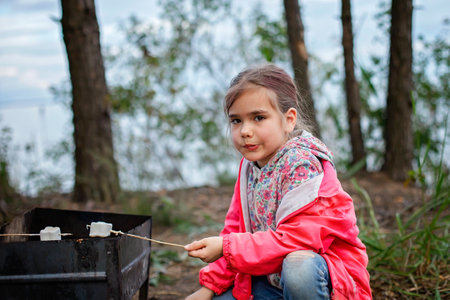 New normal escape step, wild nature walking and family outdoor recreation. Kids cooking and tasting marshmallows fried on fire, hike at weekend, lifestyleの写真素材