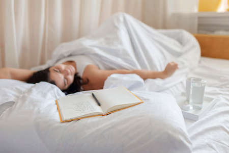 Mental health care, positive thinking and wellness concept. Attractive woman lying in bed,...