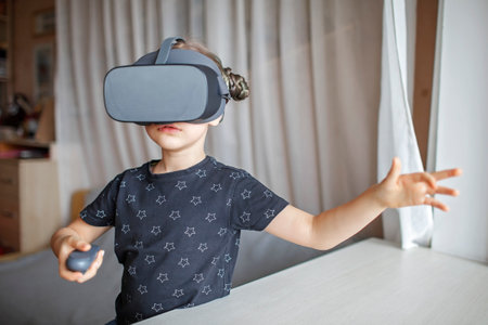 Cute girl wearing virtual reality at home, remote education experiment, future today, new online education, indoor lifestyleの写真素材