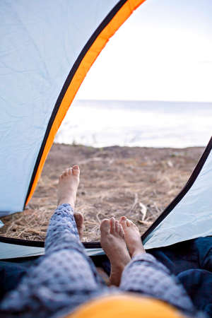 Family local getaway. Kid sitting in the camping tent at campsite and looking at sea, healthy active lifestyle, safe summer, stay location conceptの写真素材