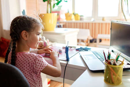 Cute girl doing flowers with toilet roll tube for Easter and Mother Day via online master class,...