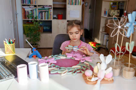 Cute girl doing flowers with toilet roll tube for Easter and Mother Day via online master class, zero waste crafts for kids, school and kindergarten, creative idea for holidays from internetの写真素材