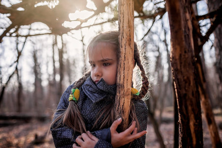 Young adventurers, boy and girl, building a wooden habitat in the wild forest during their social distant walking in lockdown time, walking on fresh air, outdoor active lifestyleの写真素材