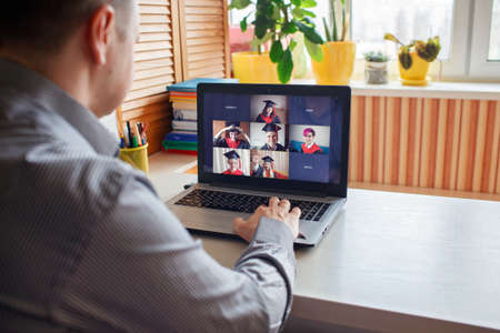 Virtual graduation and convocation ceremony. Laptop screen with happy students wearing graduation...