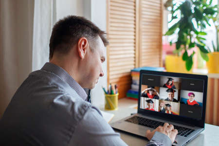 Virtual graduation and convocation ceremony. Laptop screen with happy students wearing graduation...