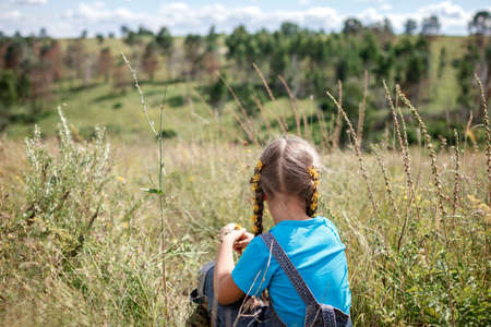 Happy girl with yellow dandelions in her hair relaxing away on nature, digital detox, escape and...