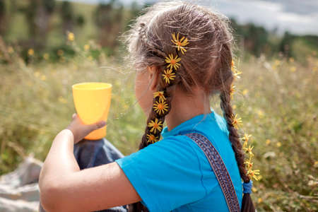 Happy girl with yellow dandelions in her hair relaxing away on nature, digital detox, escape and...