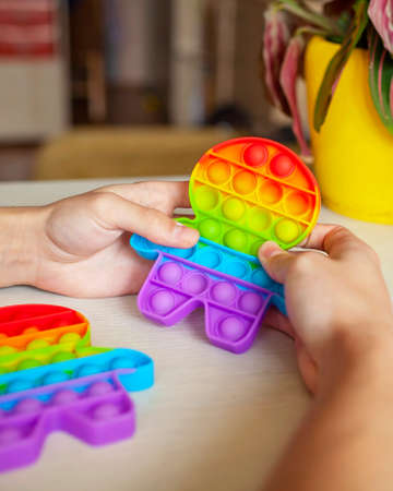 Young man playing with fidget sensory toy to relieve stress, simple way to be in calm and harmony, mental health conceptの写真素材