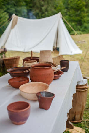 Craft ceramist demonstrates the products of his work on the festival workshop, clay jars and pots at potter workplace, diy, master of artisanal thing, middle age re-enactmentの写真素材