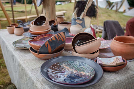 Craft ceramist demonstrates the products of his work on the festival workshop, clay jars and pots at potter workplace, diy, master of artisanal thing, middle age re-enactmentの写真素材