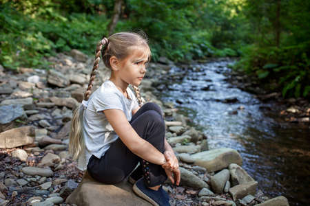 A cute girl walking in the woods, solo tourist hiking to explore nature and discover herself, wellness and slow living concept, summer outdoor activityの写真素材