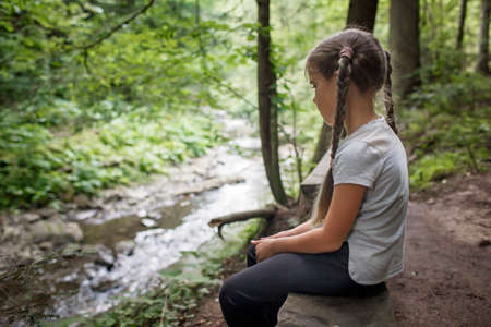A cute girl walking in the woods, solo tourist hiking to explore nature and discover herself, wellness and slow living concept, summer outdoor activityの写真素材