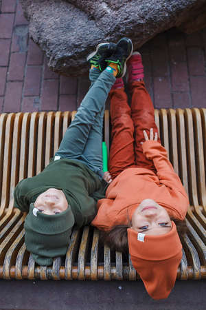 Kids in trendy hats and hoodies having fun in the park, fall vibes, autumn beauty style, child fashion, seasonal fashion. Outdoor active lifestyleの写真素材