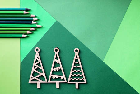 Tree simple wooden trees and many various shade of green color pencils lay on the green color gradation paper background, craft and diy concept for kid and kindergartenの写真素材
