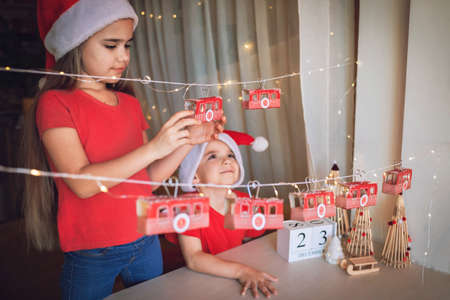 Happy kid plays with original advent calendar on theme of ski and cable car. Funicular advent calendar with toilette paper rolls. Zero waste and reusable Christmas. Magic winter holiday, focus on kidの写真素材