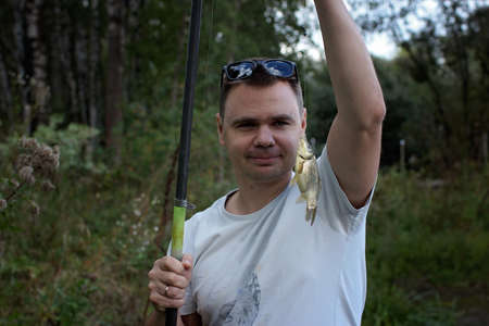 Portrait of adult man fishing with rods in early spring day, family weekend concept, outdoorの写真素材