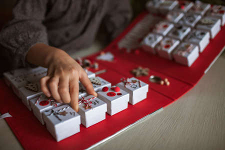 Original advent calendar made of jewelry boxes and a binder, New Year craft, diy. Pretty girl open one of gift boxes, magic of moment, seasonal activity, Christmas miracle. Soft focus, depth of fieldの写真素材