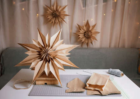 Making of DIY paper bag stars with brown paper lunch bags, craft Christmas paper decoration, tutorial. Ecological and sustainable celebration. Quick and easy winter activity with kidsの写真素材