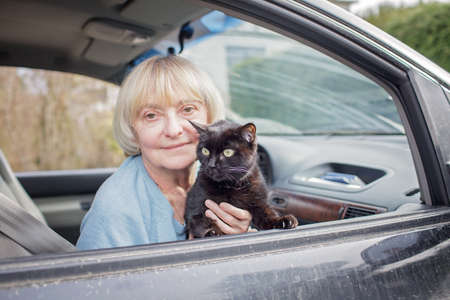 Family of Ukrainian refugees, seniors, woman and kids, fleeing from war against Russia and cross the board by car together with pet. World terrorism and war. Volunteering and helping handの写真素材