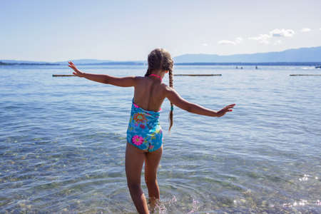 Happy girl going into the blue water, lots of fun and happiness, summer vacations, travel and summertime, lifestyleの写真素材