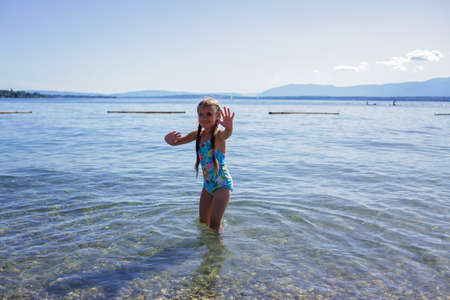 Happy girl going into the blue water, lots of fun and happiness, summer vacations, travel and summertime, lifestyleの写真素材