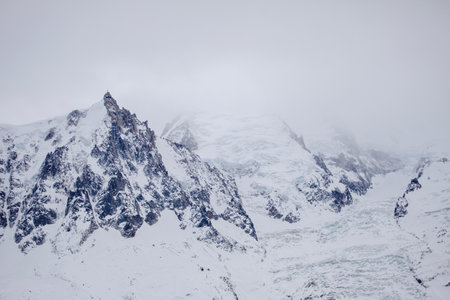 Misty view of ridge of European Alps in winter, ski resort Chamonix Mont-Blanc, France. Ideal place for extreme sport and hiking. Winter activity. Natural backgroundの写真素材