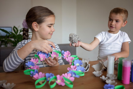 Transformation an ordinary egg carton into a beautiful Easter flower wreath. Kids show the creative and sustainable possibilities of Zero Waste lifestyle. Reduce, reuse, and recycle. DIY with kidsの写真素材