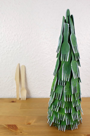 DIY Christmas tree from wooden forks and spoons. Zero waste with kids, eco-friendly decor concept. Space for text, green holiday spirit. Vertical format.の写真素材
