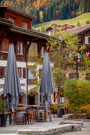 A village in the French Alps displays a unique blend of seasons, with autumns golden foliage contrasted by early winter snow on surrounding peaks. Travel and active lifestyle. Peaceful calmの写真素材