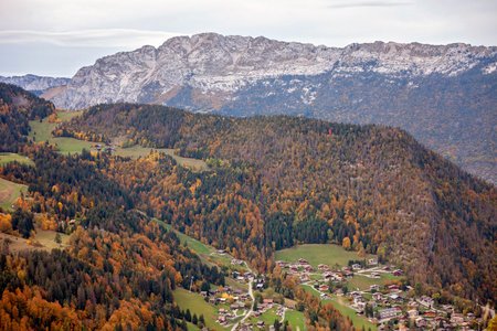 A village in the French Alps displays a unique blend of seasons, with autumns golden foliage contrasted by early winter snow on surrounding peaks. Travel and active lifestyle. Peaceful calmの写真素材