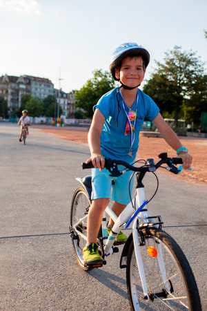 A confident schooler enjoys a city bike ride, smiling under their helmet. This photo showcases the balance of safety and vitality, emphasizing the benefits of cycling for health and recreation.の写真素材