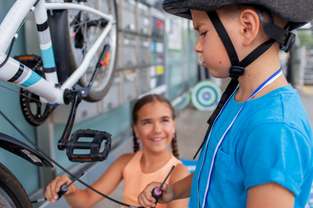 A focused child is engaged in bike repair, showcasing concentration and practical skills. This image highlights hands-on learning, making it ideal for themes of hobbies, family time, and activeの写真素材
