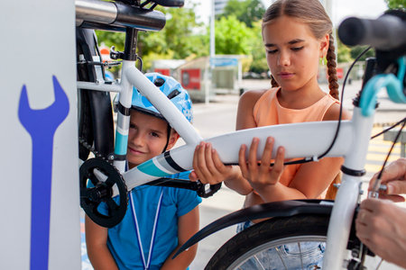 A young child works on a bicycle, fully absorbed in the process of fixing and learning. Perfect for illustrating productive activities, childhood curiosity, and family-oriented hobbies.の写真素材