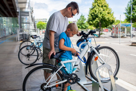 A father helps his child fix a bicycle, showcasing teamwork and hands-on learning. Perfect for themes of family bonding, practical skills, and active pastimes.の写真素材