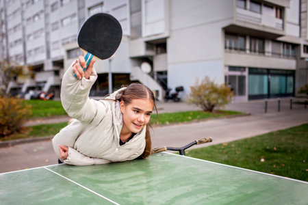 Authentic photo of teenagers enjoying table tennis. Offline recreation focused on movement, awareness, and balance without gadgets.の写真素材