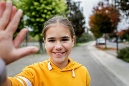Spring lifestyle photo of a teenage girl in a bright yellow hoodie. Fresh energy and joyful presence...