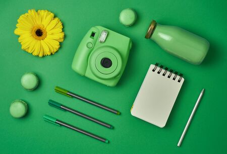 camera pens and notebook on green backgroundの写真素材